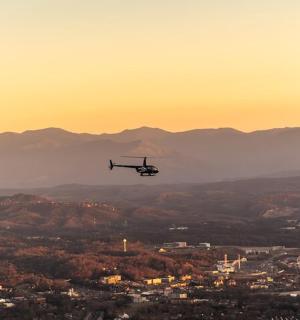 日落时分，一架直升机飞越城市上空