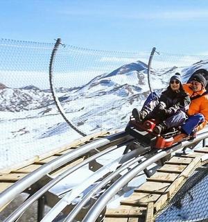 两个人坐在雪地里的过山车上