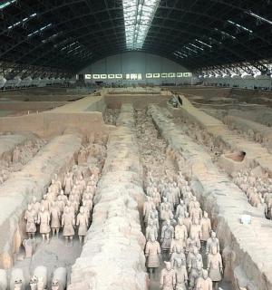 a large room filled with lots of grey statues