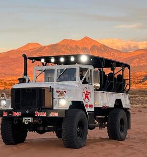 a truck parked in the desert with mountains in the background