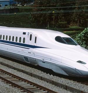 a white bullet train is on the tracks