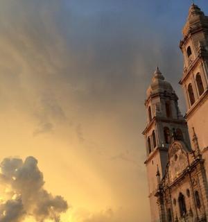 a building with a clock tower with a cloudy sky