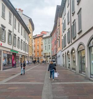 žena kráčející po městské ulici s budovami