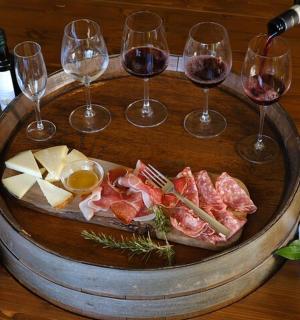 a table with wine glasses and meats and cheese