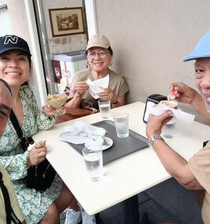 skupina lidí sedících u stolu a jedících