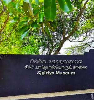 a sign for the sigiriya museum with trees in the background