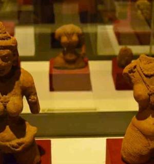 two statues in a display case in a museum