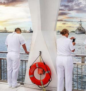 skupina lidí stojících na balkóně a dívajících se na vodu