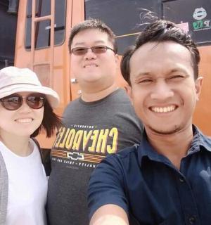 bir trenin önünde duran üç kişilik bir grup