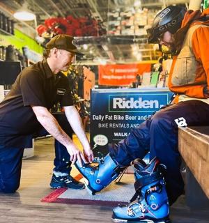 两个男人正在帮另一个男人穿鞋