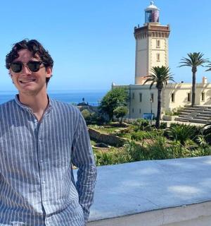 一名戴着墨镜的男子站在灯塔前