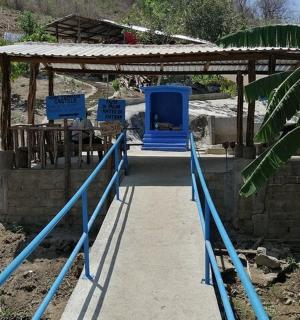 a structure with blue poles and a building with a roof