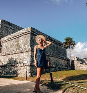 一位身穿蓝色连衣裙的女士站在一栋建筑前