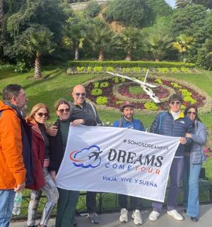 un gruppo di persone che tengono un cartello davanti a un giardino