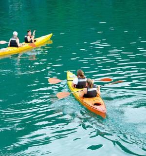 three people are riding in kayaks in the water
