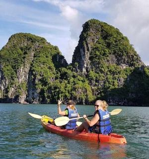 two people in a kayak in the water with mountains