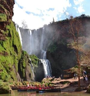 eine Gruppe von Menschen steht vor einem Wasserfall