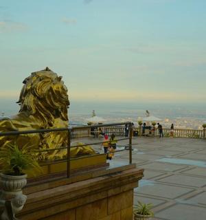 uma estátua de leão de ouro sentada no topo de um edifício