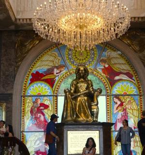 uma estátua de uma mulher em um prédio com um lustre