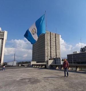 a man flying a kite in front of two buildings