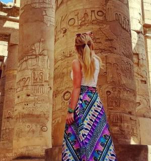 a woman standing in front of an ancient building