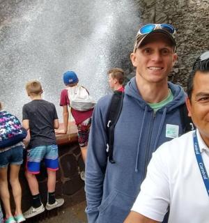 two men standing in front of a waterfall