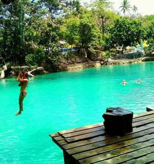 a woman jumping into a pool of blue water