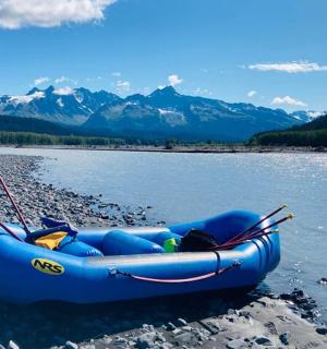 一艘蓝色的木筏停在河岸边