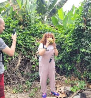 a woman taking a picture of a man with a banana