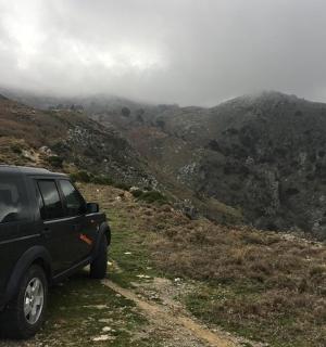 Černý nákladní vůz zaparkovaný na prašné cestě na hoře