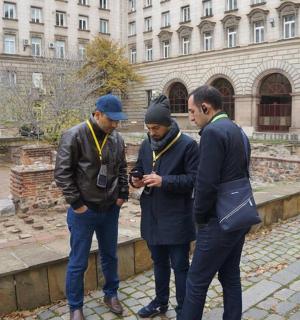a group of three men looking at a cell phone