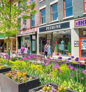 a street with a bunch of flowers in front of a store