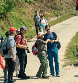 skupina lidí stojících na prašné cestě