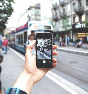 a person taking a picture of a street with a cell phone