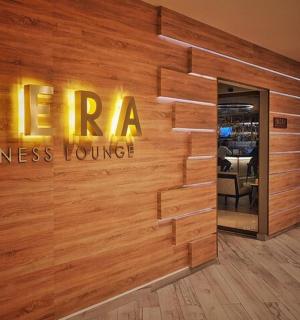 木墙上挂着 Mera 商务休息室的标志