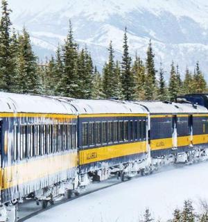 a yellow train on a track in the snow
