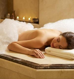 a woman laying in a bath tub with a towel