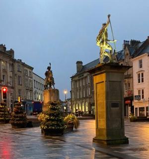 a street with a statue in the middle of a city