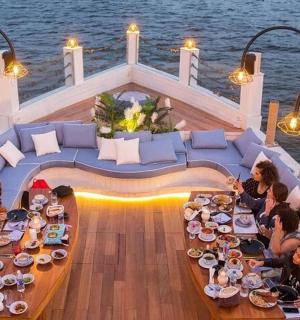 一群人围坐在船上的桌子旁