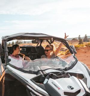 a group of people in a golf cart in the sand