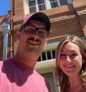 a man and a woman standing in front of a building