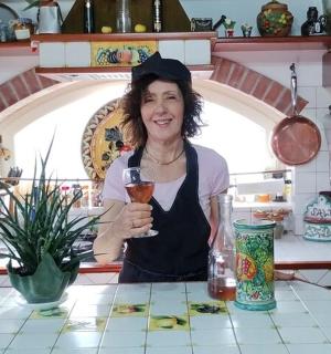 a woman in a kitchen holding a glass of wine