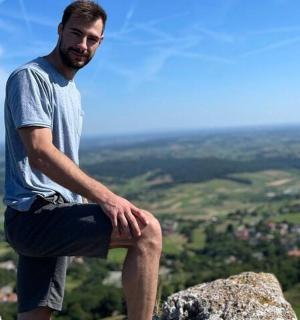 ένας άντρας κάθεται στην κορυφή ενός βράχου