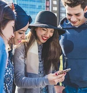 a group of people looking at a cell phone