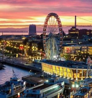 a city skyline with a ferris wheel at night