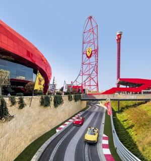 a group of cars on a road in front of a stadium