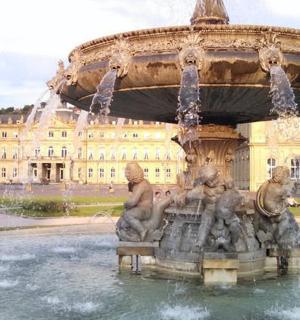 a water fountain in front of a large building