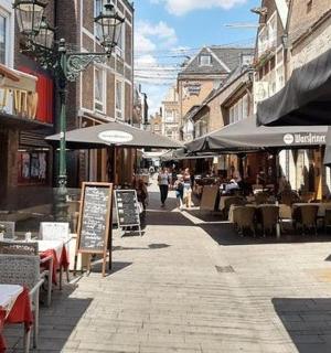 an empty street with tables and chairs and umbrellas