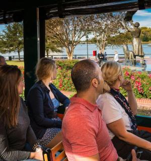 a group of people sitting on a bus looking at the water