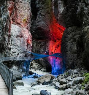 a bridge in a cave with a colorful wall